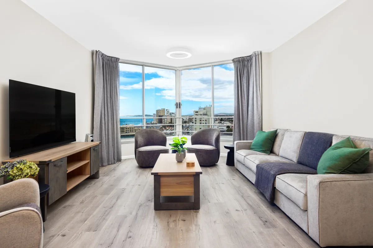 Ocean-facing lounge with comfortable seating and a smart TV in apartment 1102