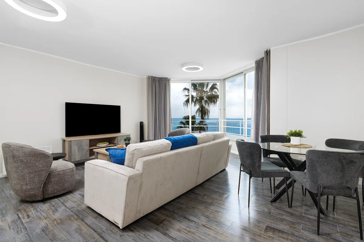 Comfortable lounge and dining space beside the beachfront windows